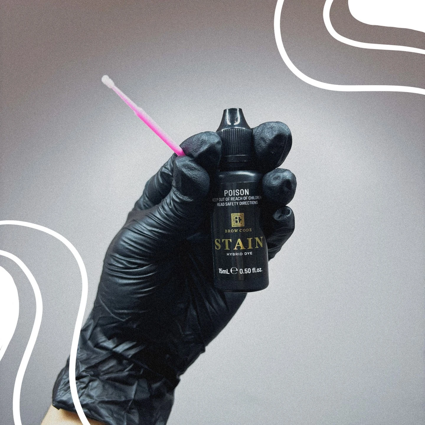 Gloved hand holding a bottle of hybrid dye stain with applicator brush